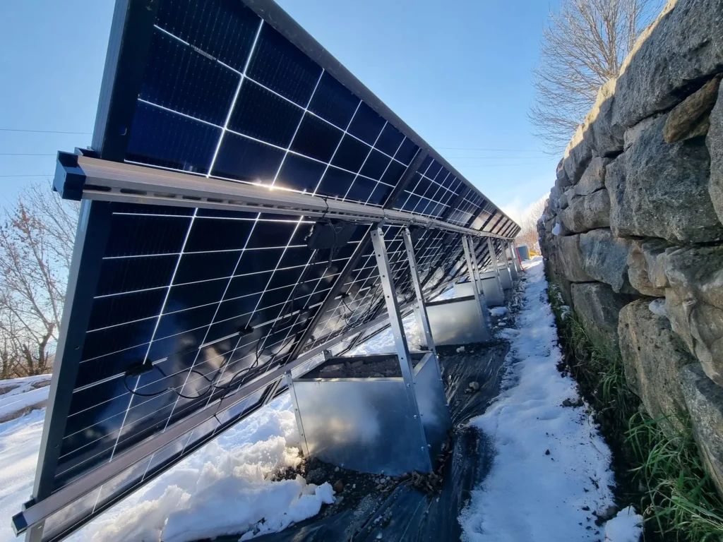 Centrale photovoltaïque posée au sol en montagne, avec de la neige