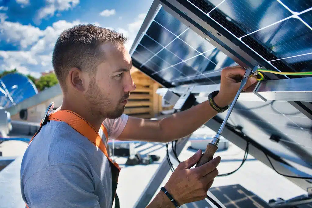 installateur de panneaux photovoltaïque en train de raccorder